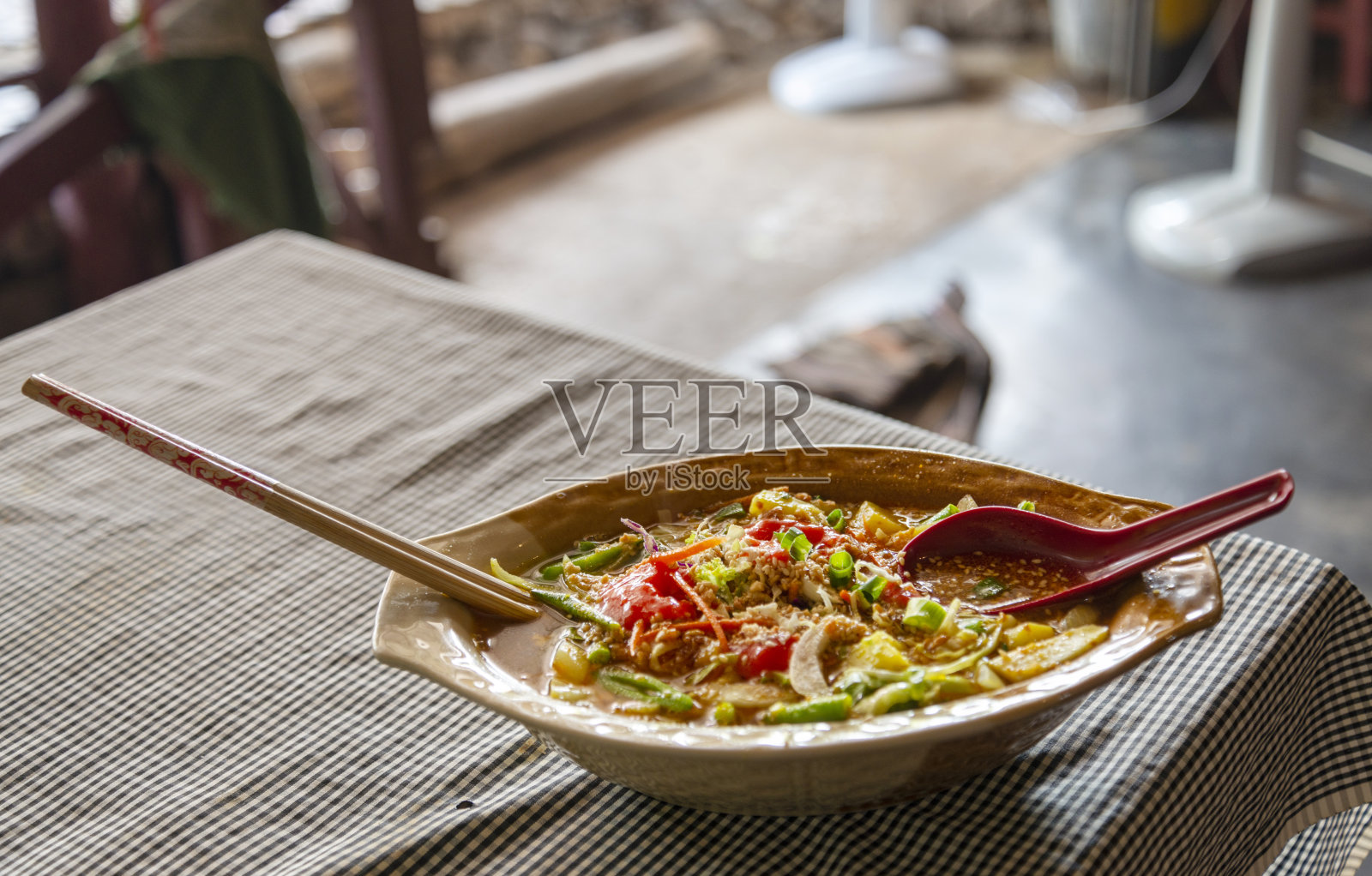 麻辣的马来西亚风味猪肉和蔬菜,用筷子夹在碗里,Pai,泰国。照片摄影图片
