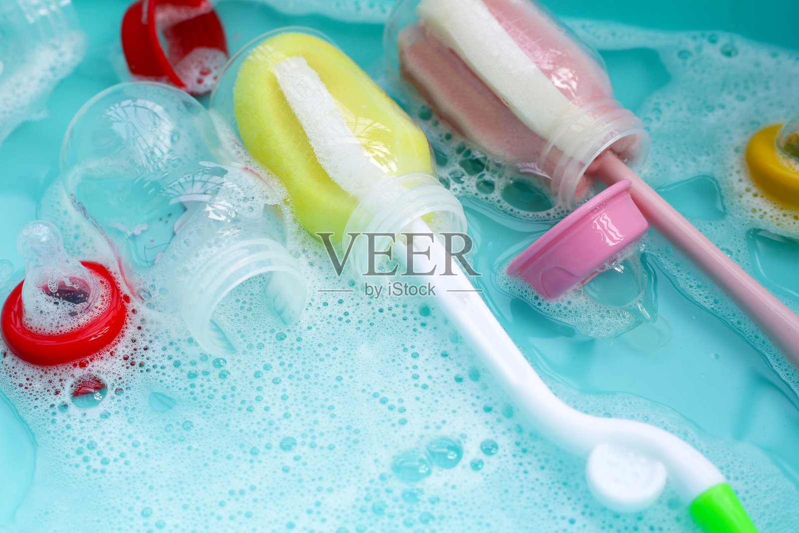 用蓝色塑料盆洗奶瓶照片摄影图片