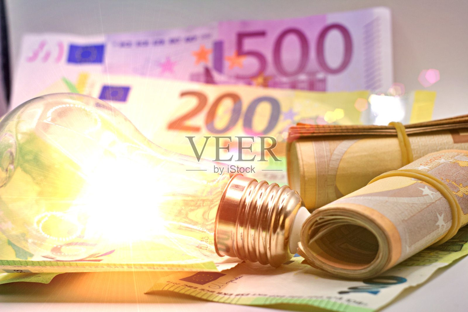 不断上升的能源成本概念。欧元钞票上的灯泡。照片摄影图片