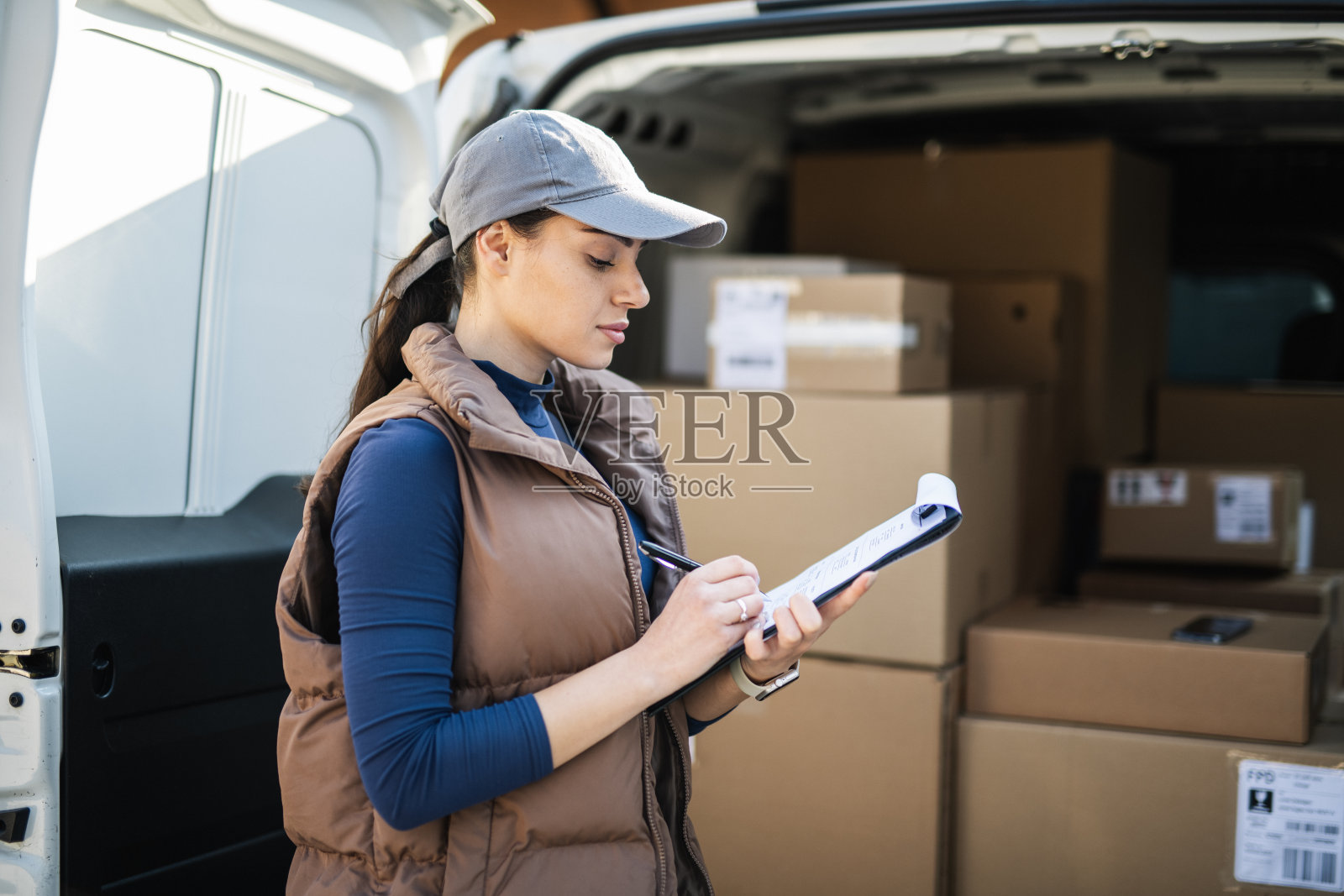 送包裹的年轻女子。照片摄影图片