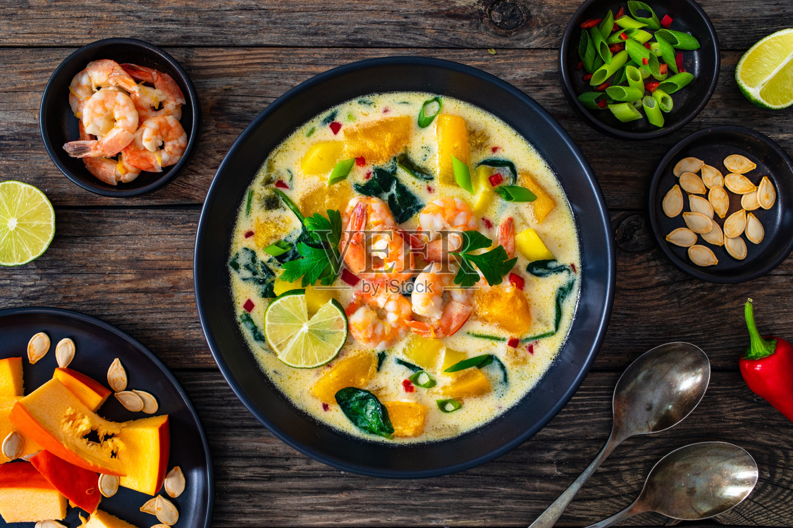 木桌上有南瓜、虾和椰奶的泰国汤照片摄影图片