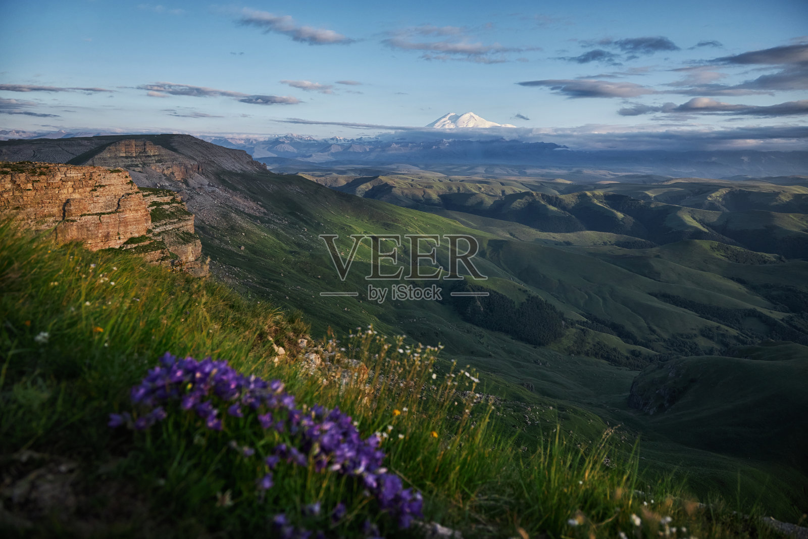 高加索山脉的大自然在每个季节都展现出令人惊叹的美丽。充满活力的野花盛开在高山草地上,雄伟的山脉矗立在蔚蓝的天空下照片摄影图片