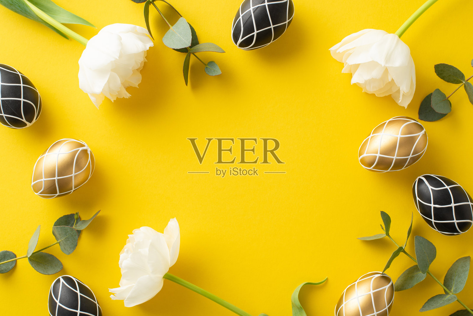 重新想象复活节的富裕。奢华的黑色和金色的鸡蛋,原始的桉树树枝,通风的郁金香花,在醒目的黄色表面上的俯视图快照,有空间进行复制或广告照片摄影图片