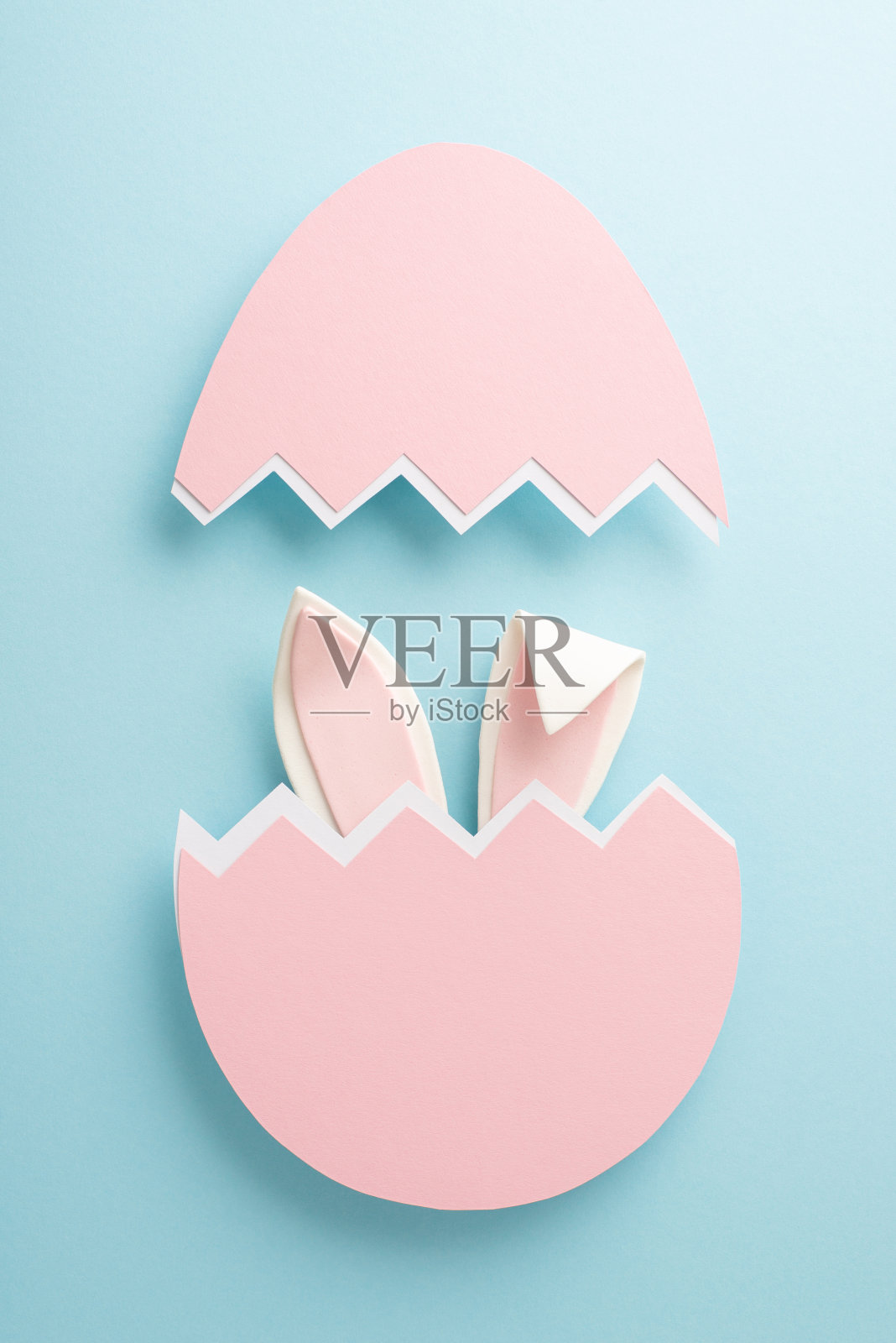 将迷人的复活节想象力带入生活。垂直顶视图捕捉了在柔和的蓝色背景上从蛋壳里窥视的古怪兔子耳朵,并留出了文字或宣传的空间照片摄影图片