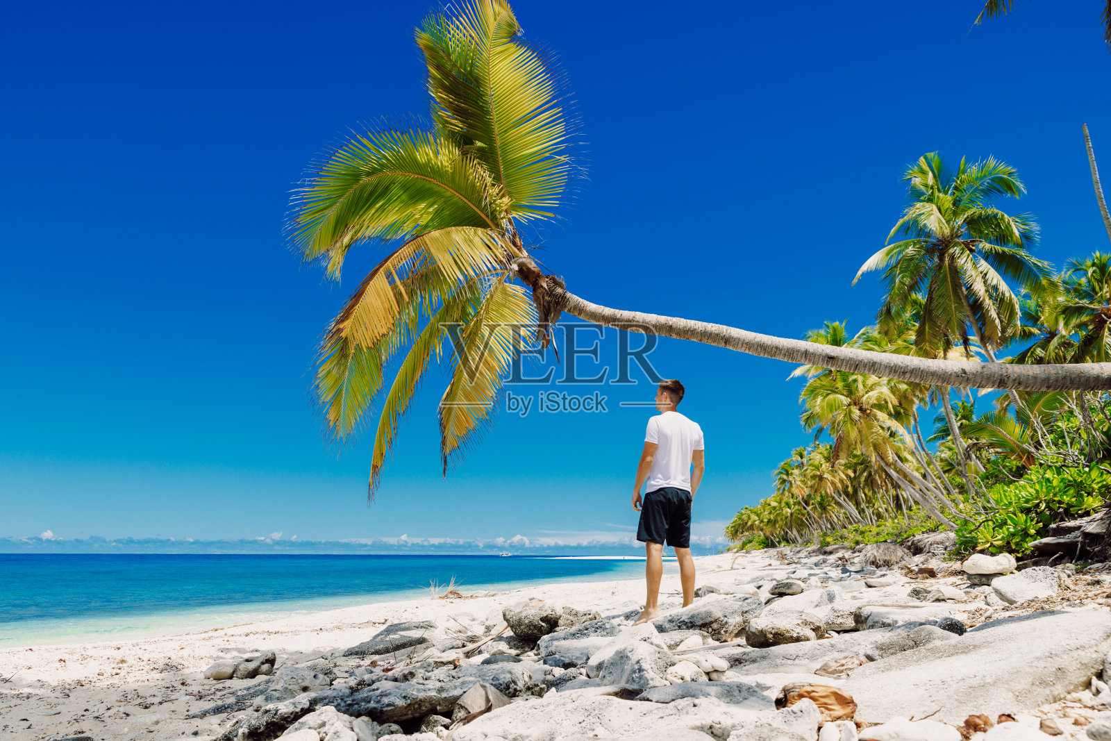 一个人在海滩上放松。瘦子在天堂海滩度假照片摄影图片