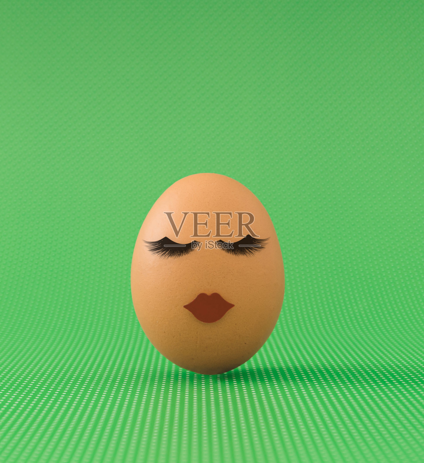 复活节彩蛋,红色的嘴唇和睫毛在绿色的背景。最小的复活节概念。创意美术,节日构思构图。复活节彩蛋美学。照片摄影图片