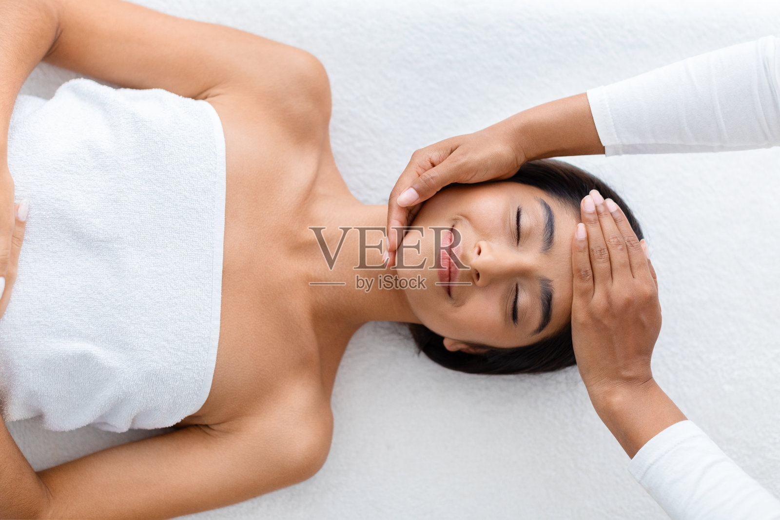 女按摩师为年轻美丽的印度女士做放松按摩照片摄影图片