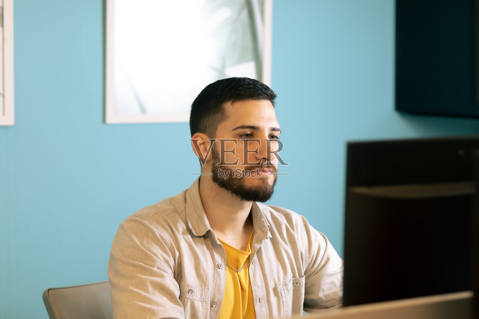 年轻人在电脑前工作。办公室的概念。照片摄影图片