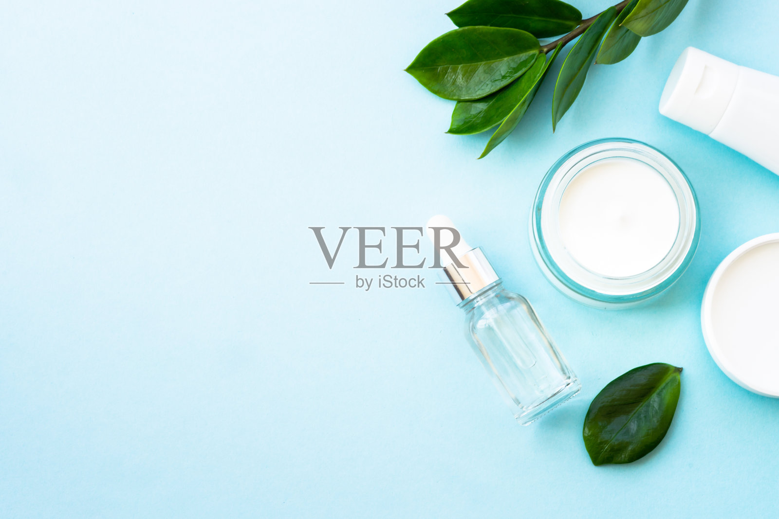 天然化妆品,蓝色的绿叶面霜罐。照片摄影图片