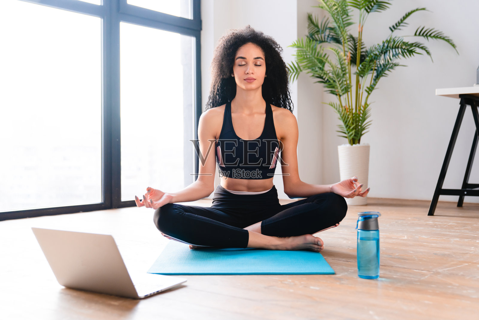 穿着健身服的年轻非洲女运动员在冥想照片摄影图片