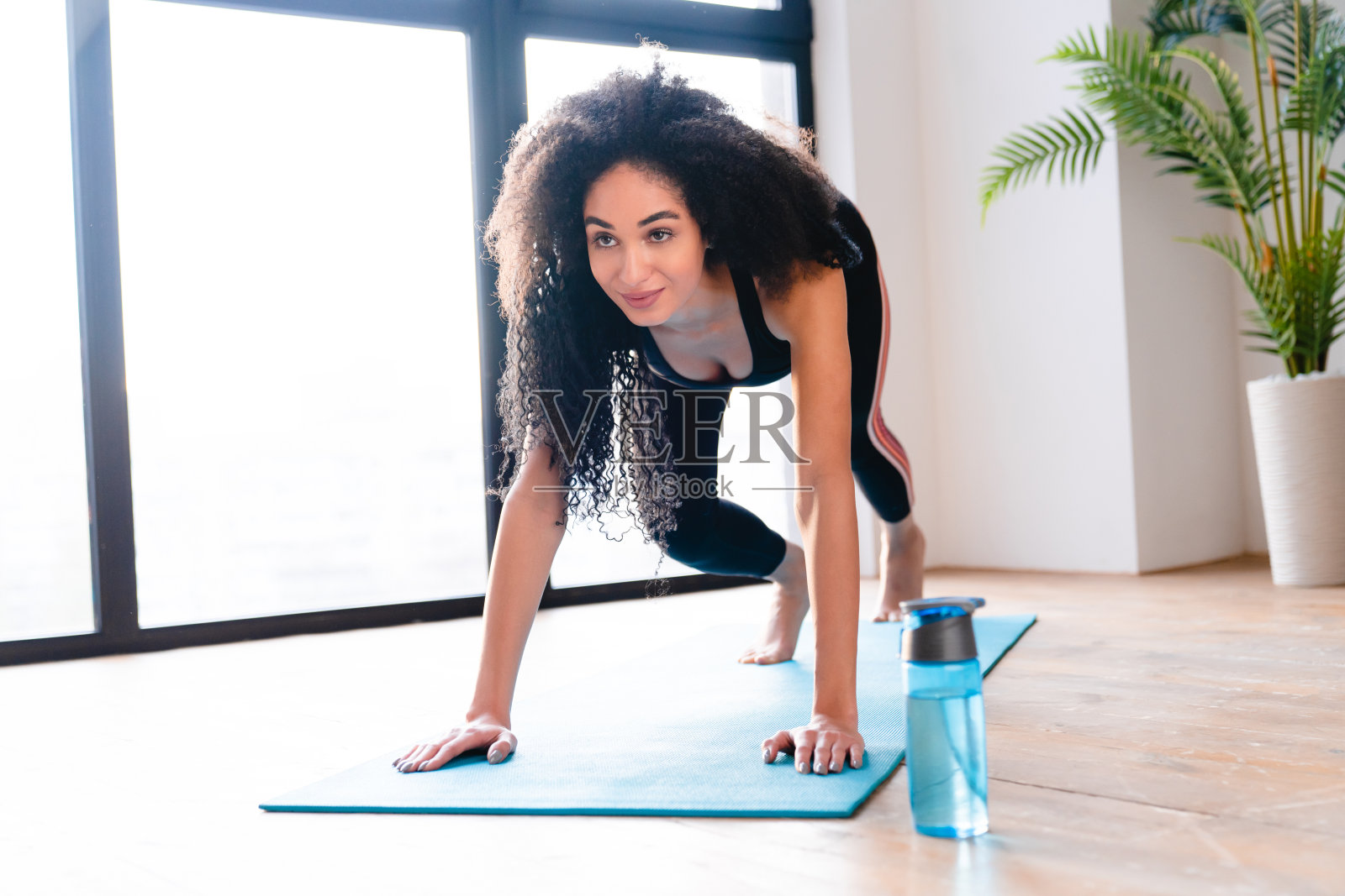 穿着运动服在健身垫上锻炼耐力的年轻女运动员照片摄影图片