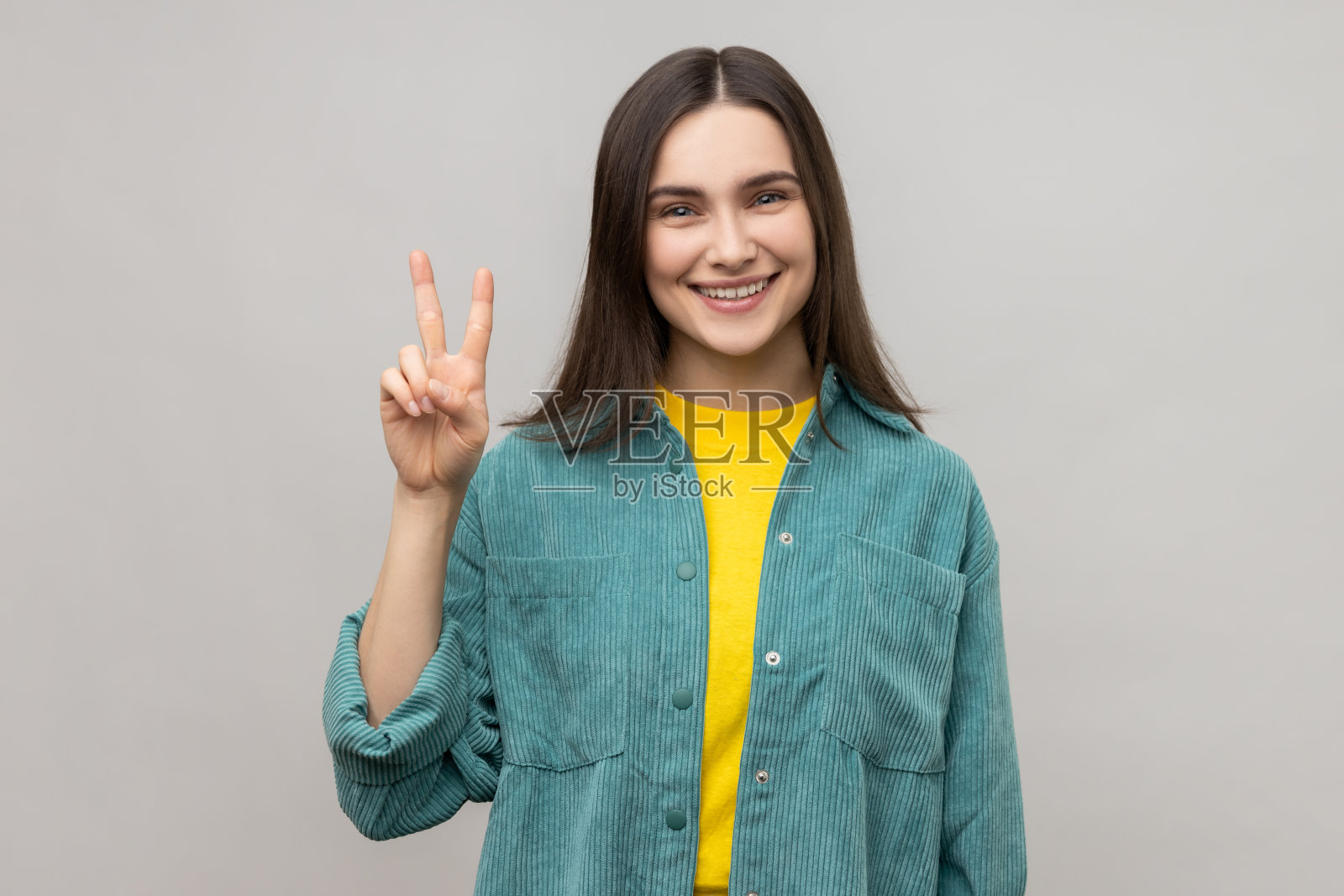 有魅力的女人在镜头前做出胜利的手势,成功或成就,表达幸福。照片摄影图片