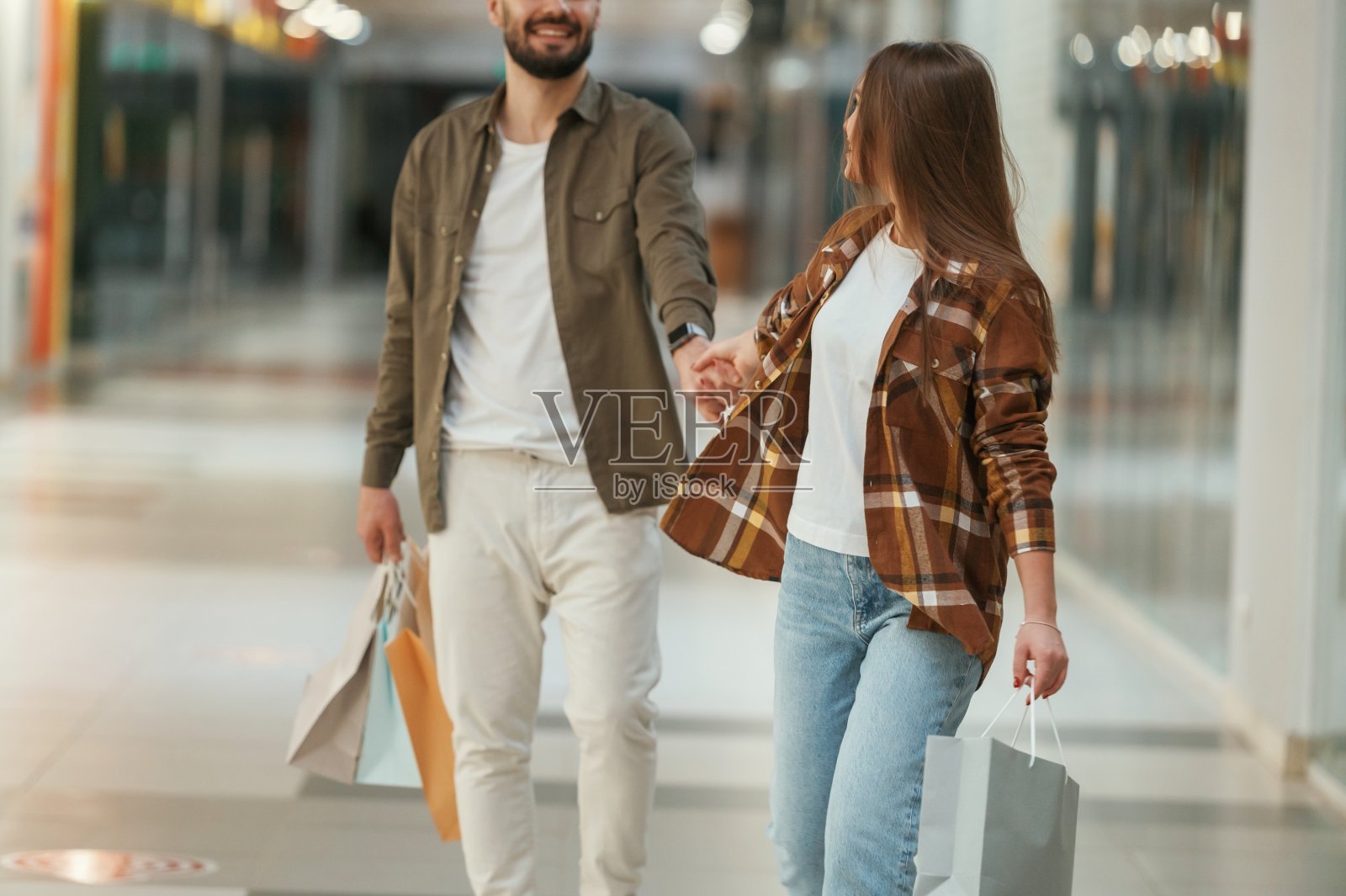 那家伙不想去购物。一对年轻的夫妇一起在超市照片摄影图片