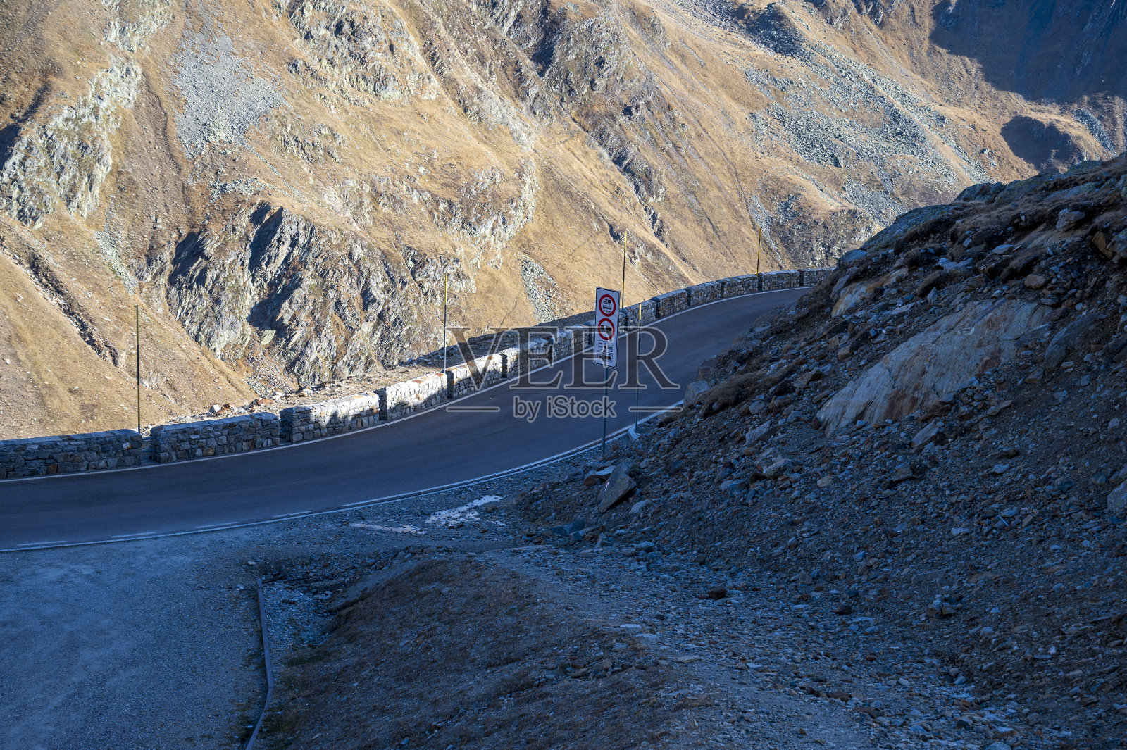 柏油路在高山上的岩石丘陵。照片摄影图片