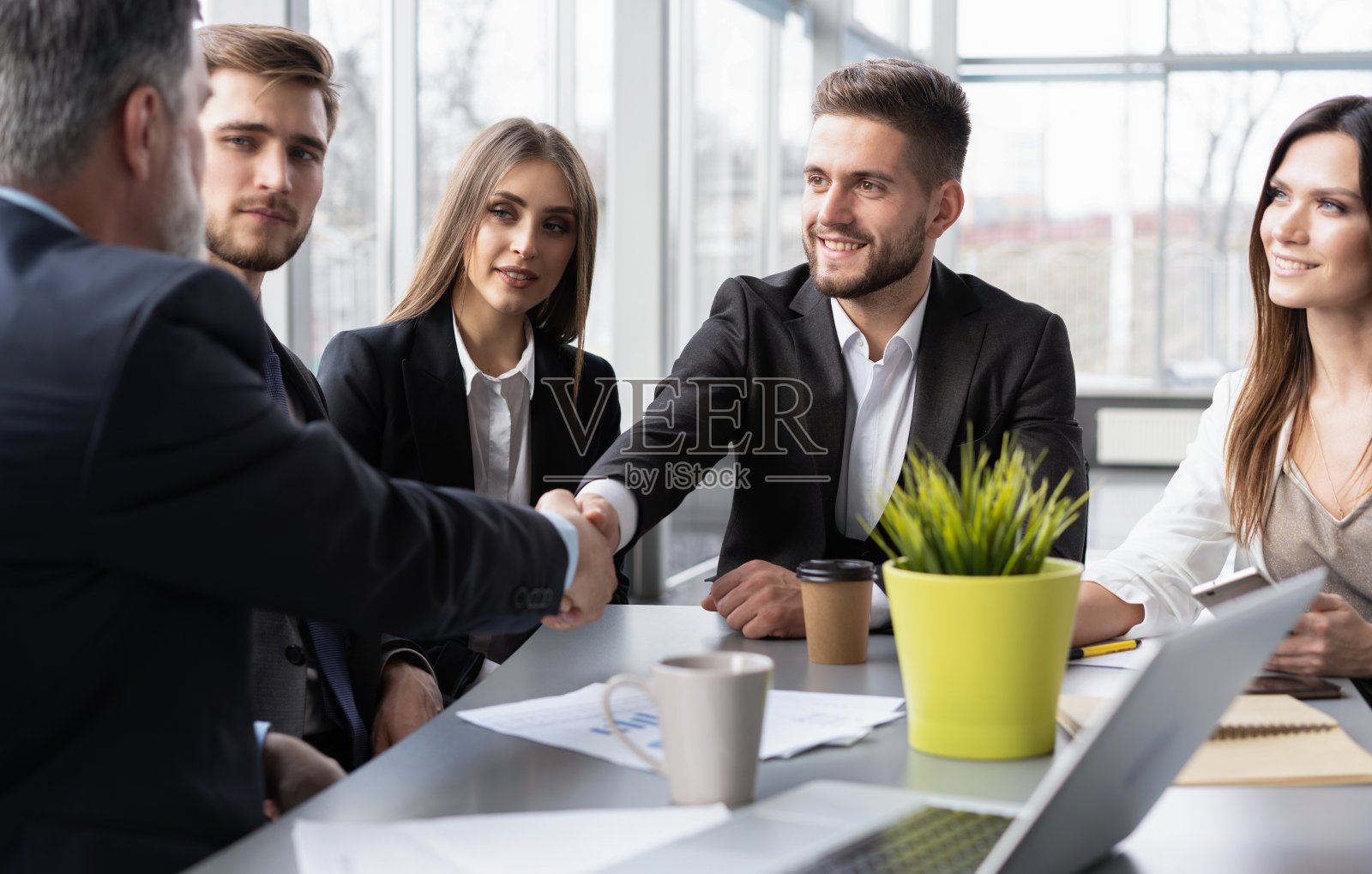 快乐的商人在集团董事会上握手。专业的商业执行领导人握手协议成功的公司贸易伙伴关系照片摄影图片