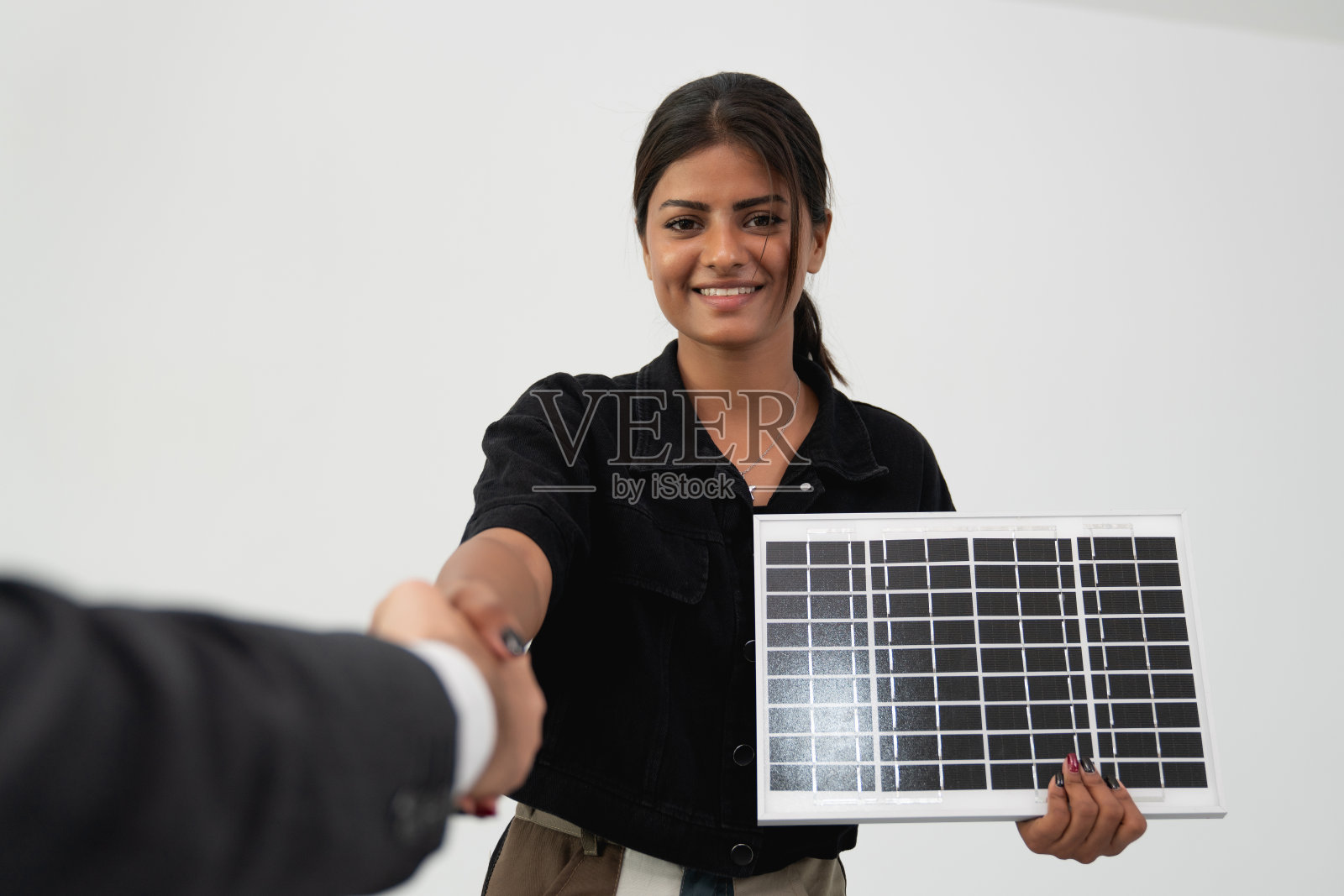 一位自信的女商人向同事展示太阳能电池板,展示在公司环境下的可再生能源解决方案。照片摄影图片
