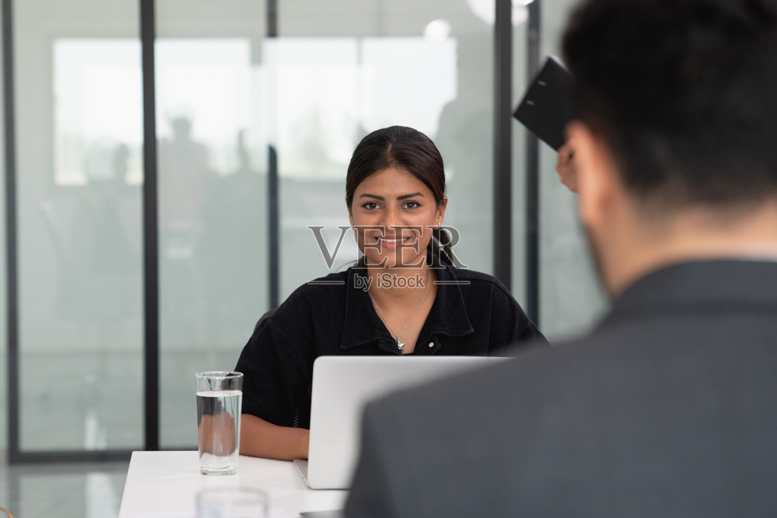 商务人士讨论文件并在笔记本电脑上工作照片摄影图片