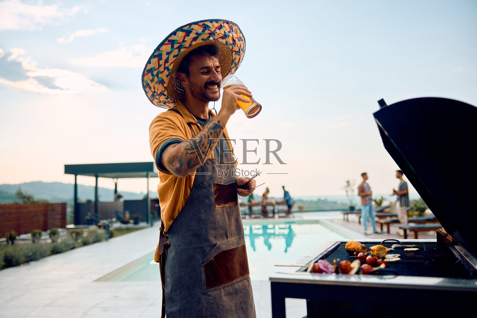 快乐的人一边喝啤酒一边烧烤。照片摄影图片