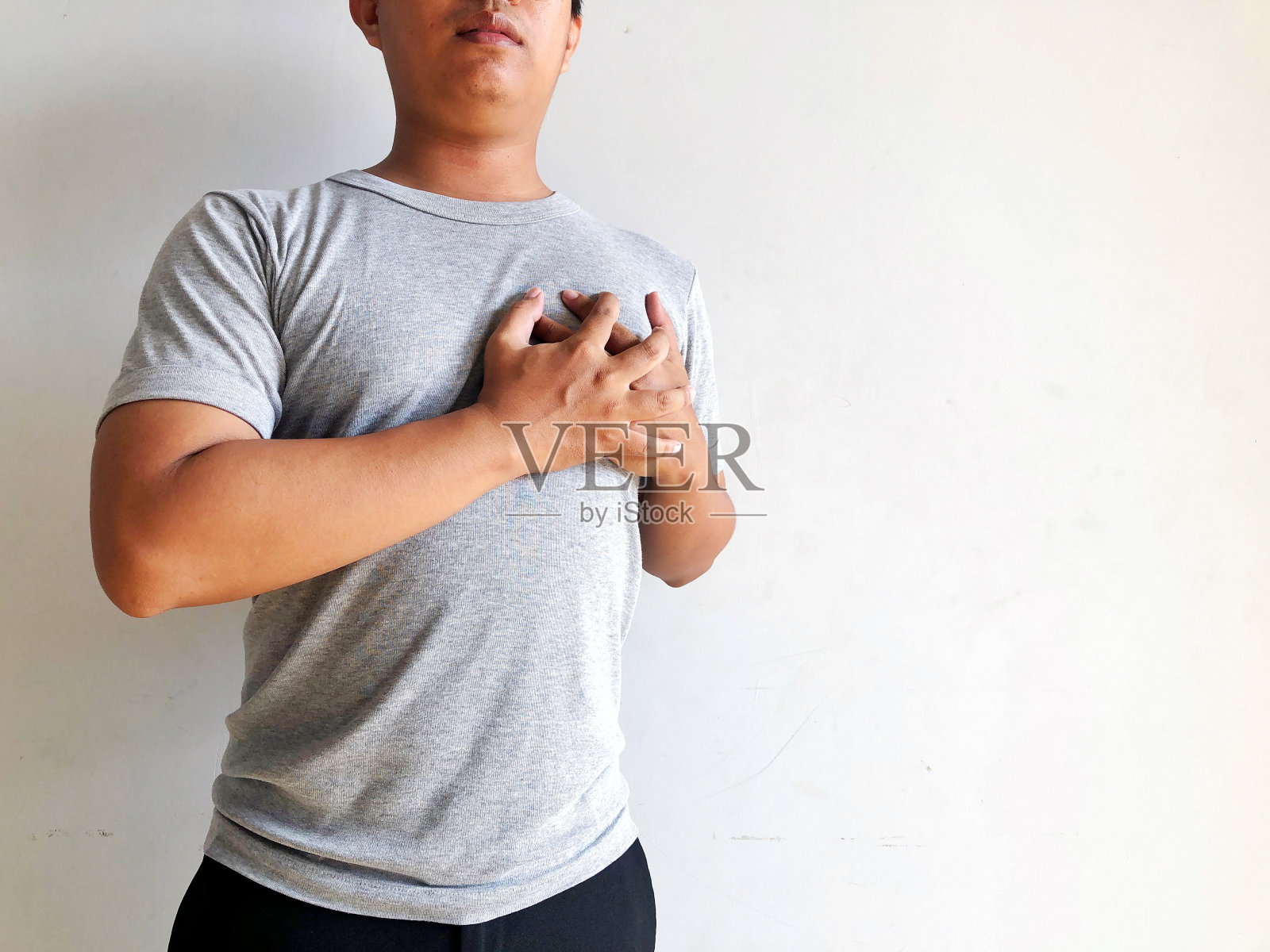 男人痛苦地捂着胸口照片摄影图片