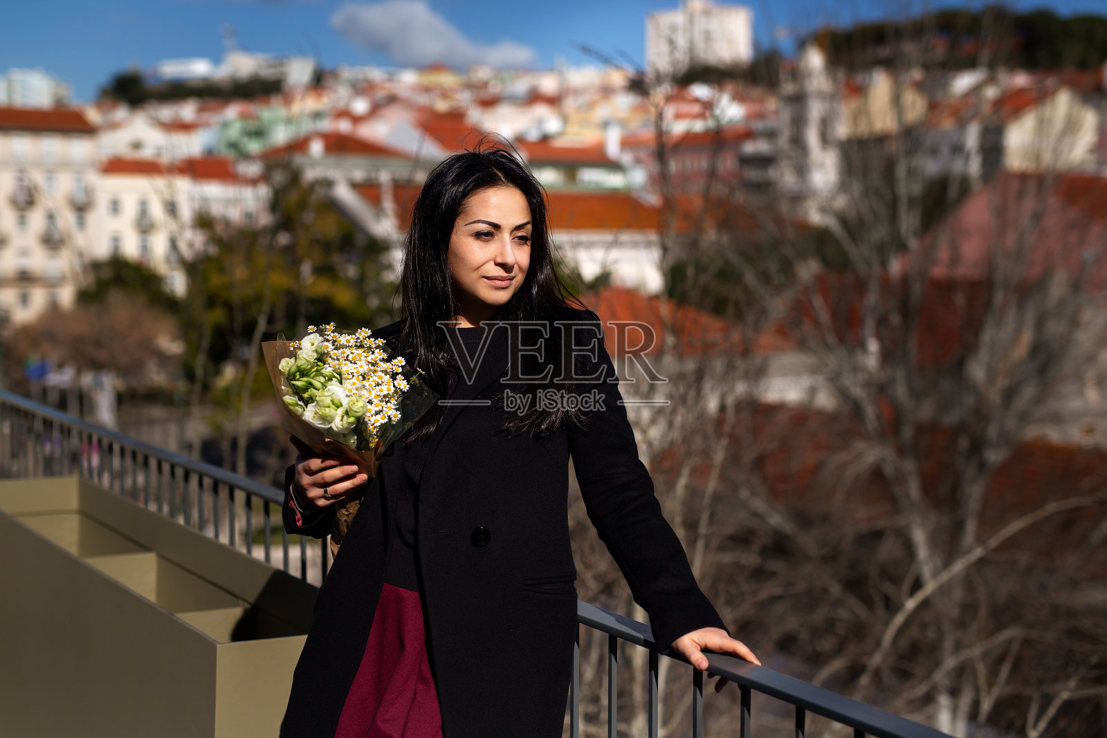 幸福、浪漫、美丽的概念。开朗漂亮的黑发年轻女子拿着一束春天的花和微笑。照片摄影图片