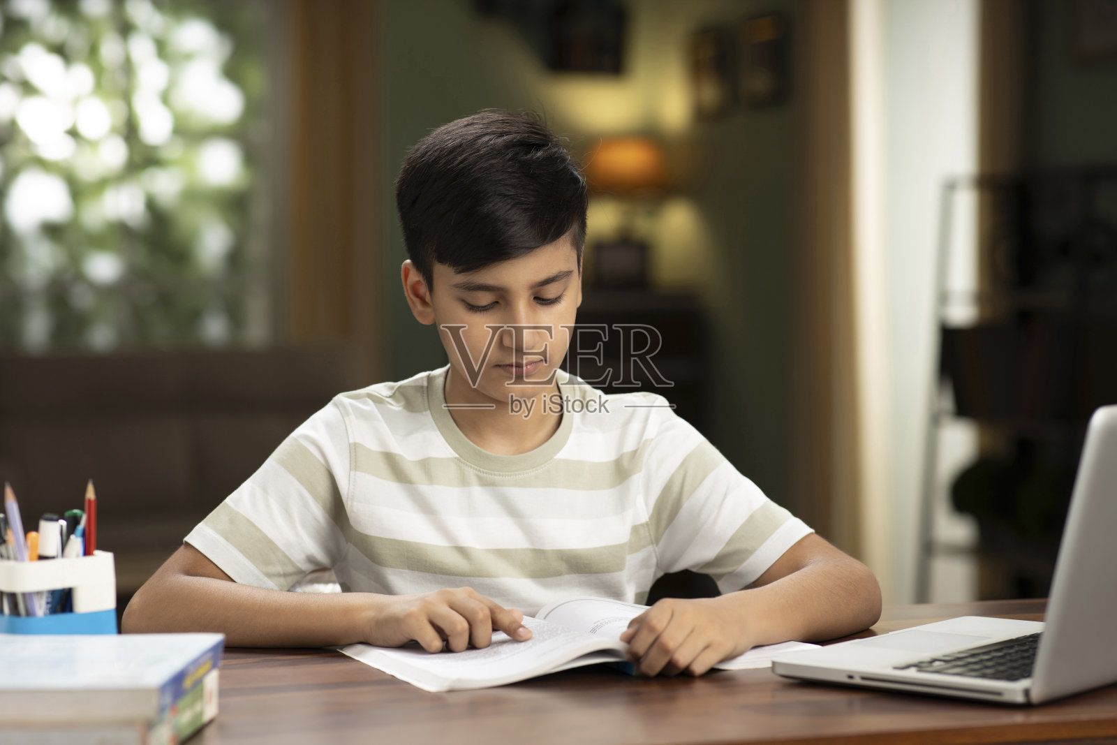 十几岁的男孩在家里学习照片摄影图片