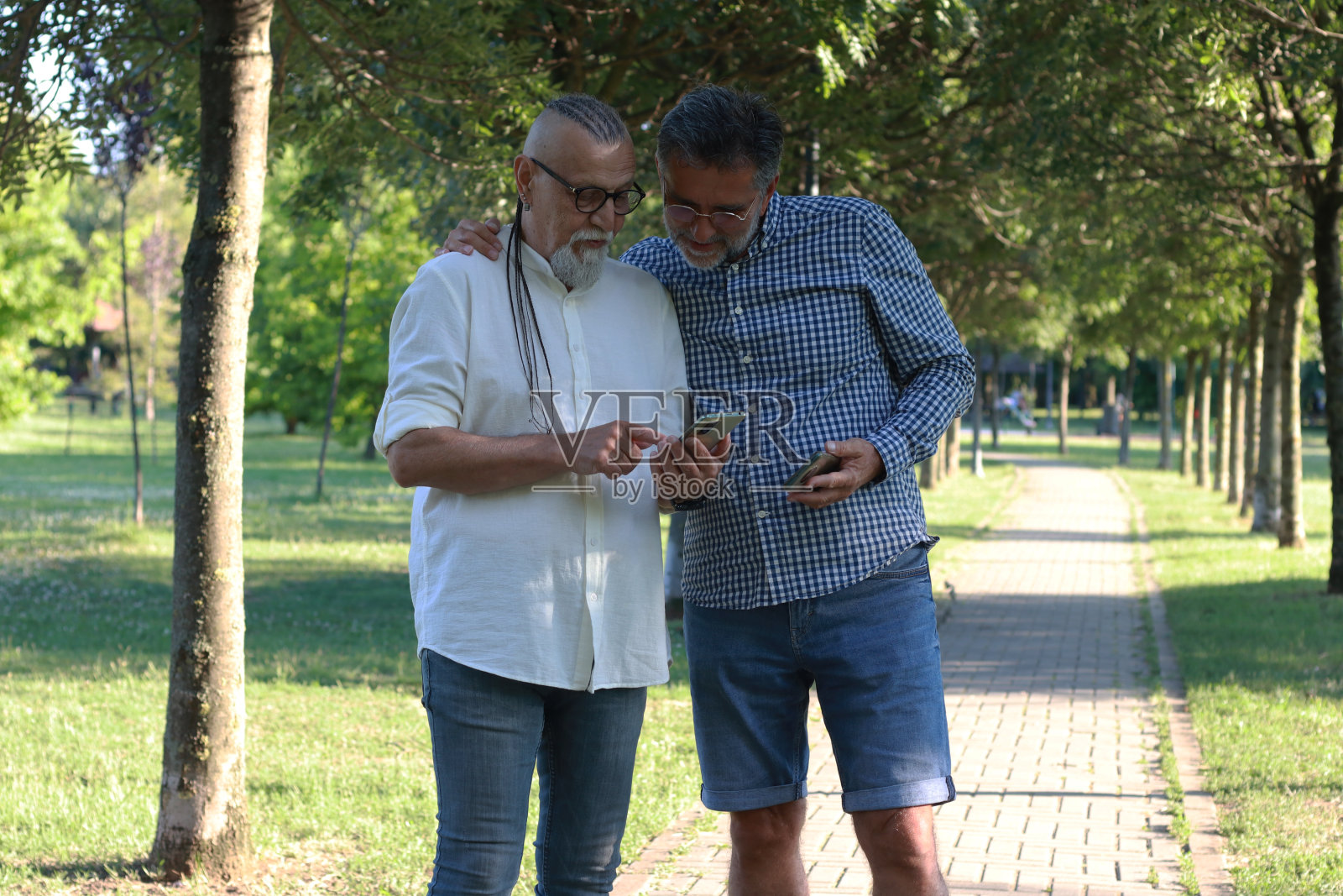 两个老人在公园里散步聊天照片摄影图片