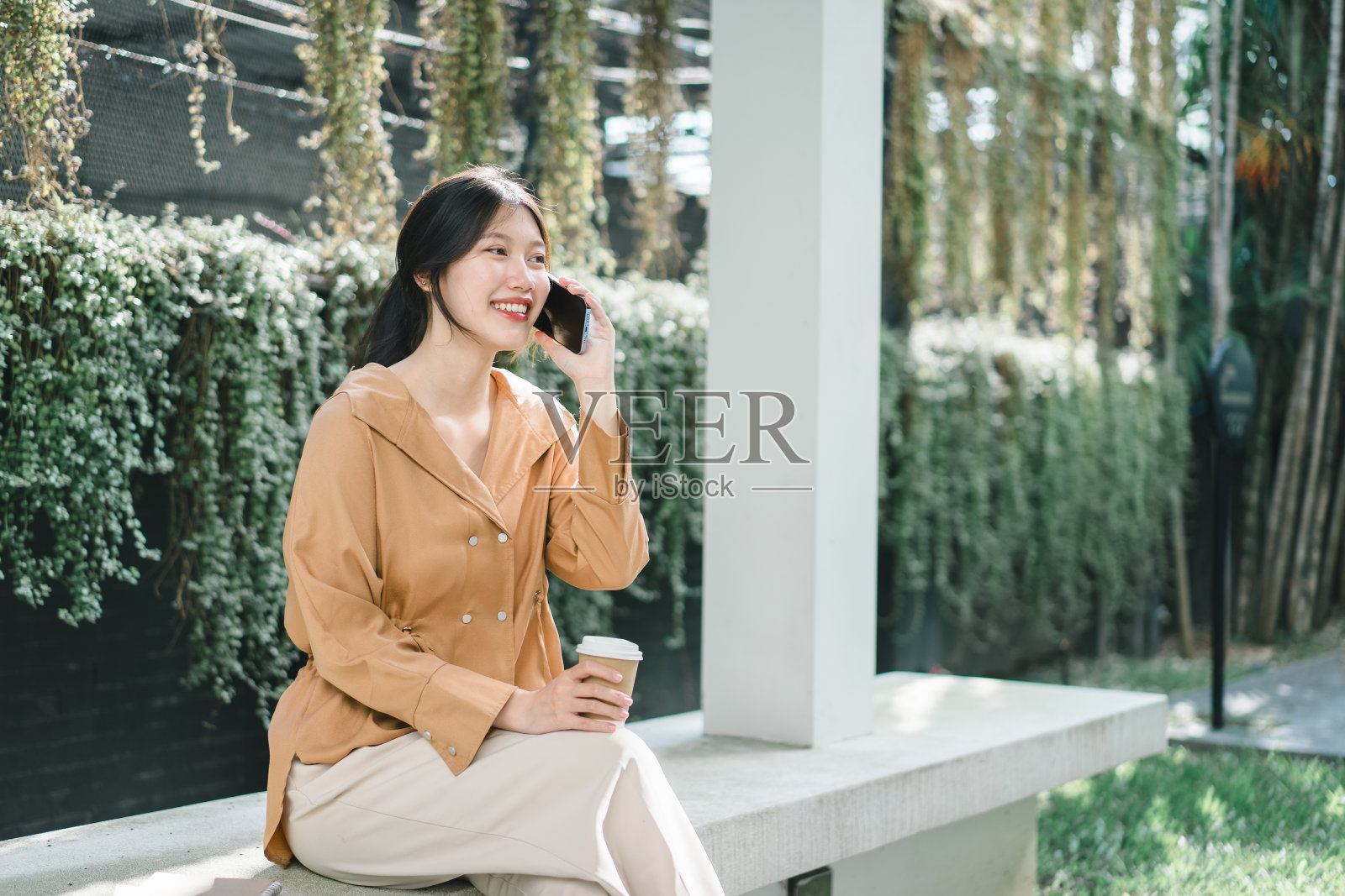 一个年轻女子在绿色的公园里享受着阳光明媚的一天。照片摄影图片