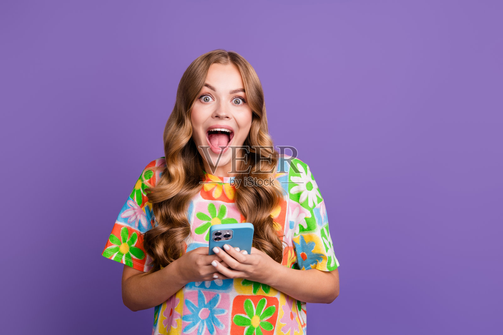 疯狂女孩的照片,当看到她最喜欢的品牌在紫色背景上的手机降价90%时,张开嘴尖叫照片摄影图片