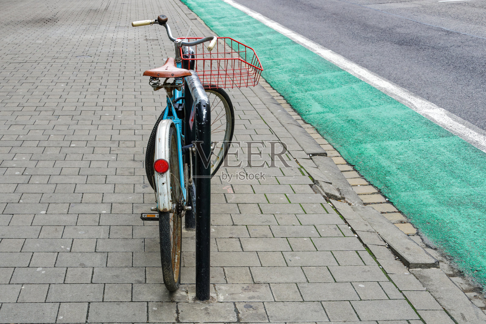 斯洛伐克,布拉迪斯拉发,一条指定自行车道旁的人行道上停放着一辆略显破旧的自行车。照片摄影图片