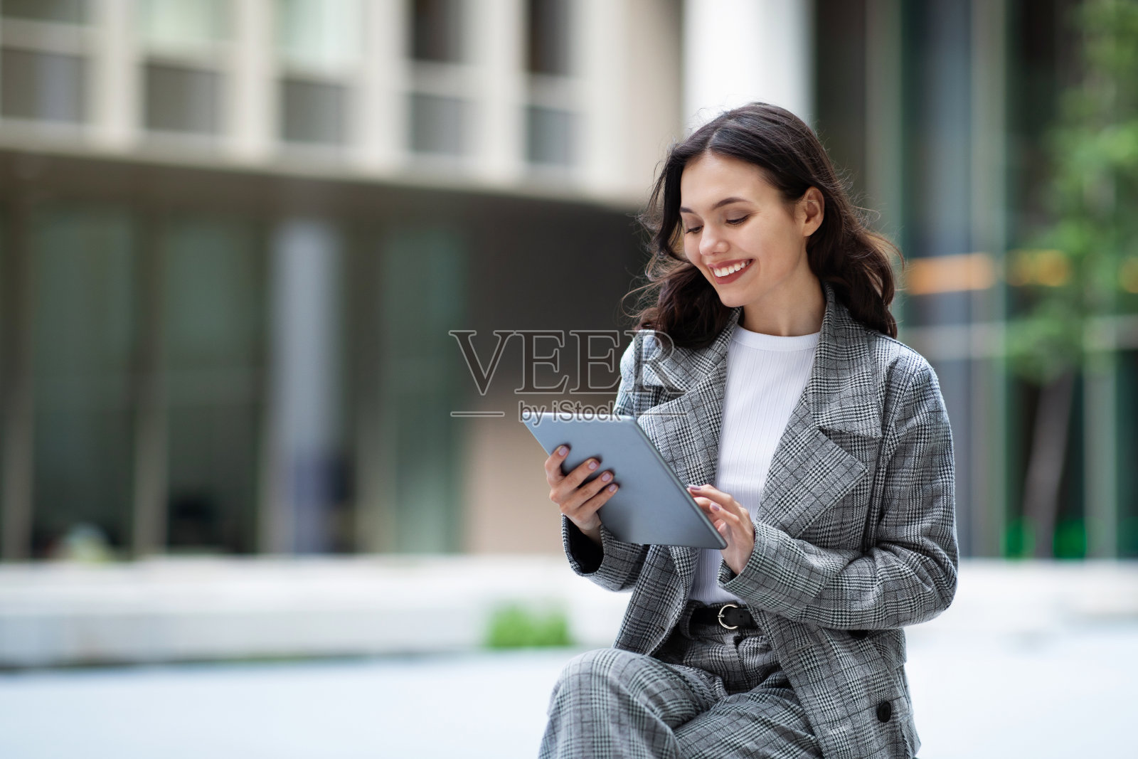 年轻妇女在城市地区使用数字平板电脑上的应用程序照片摄影图片