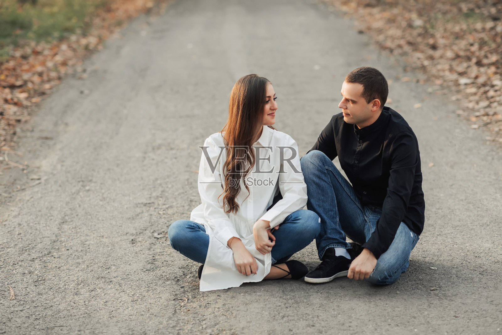 男人陪伴怀孕妻子在秋日公园休息照片摄影图片