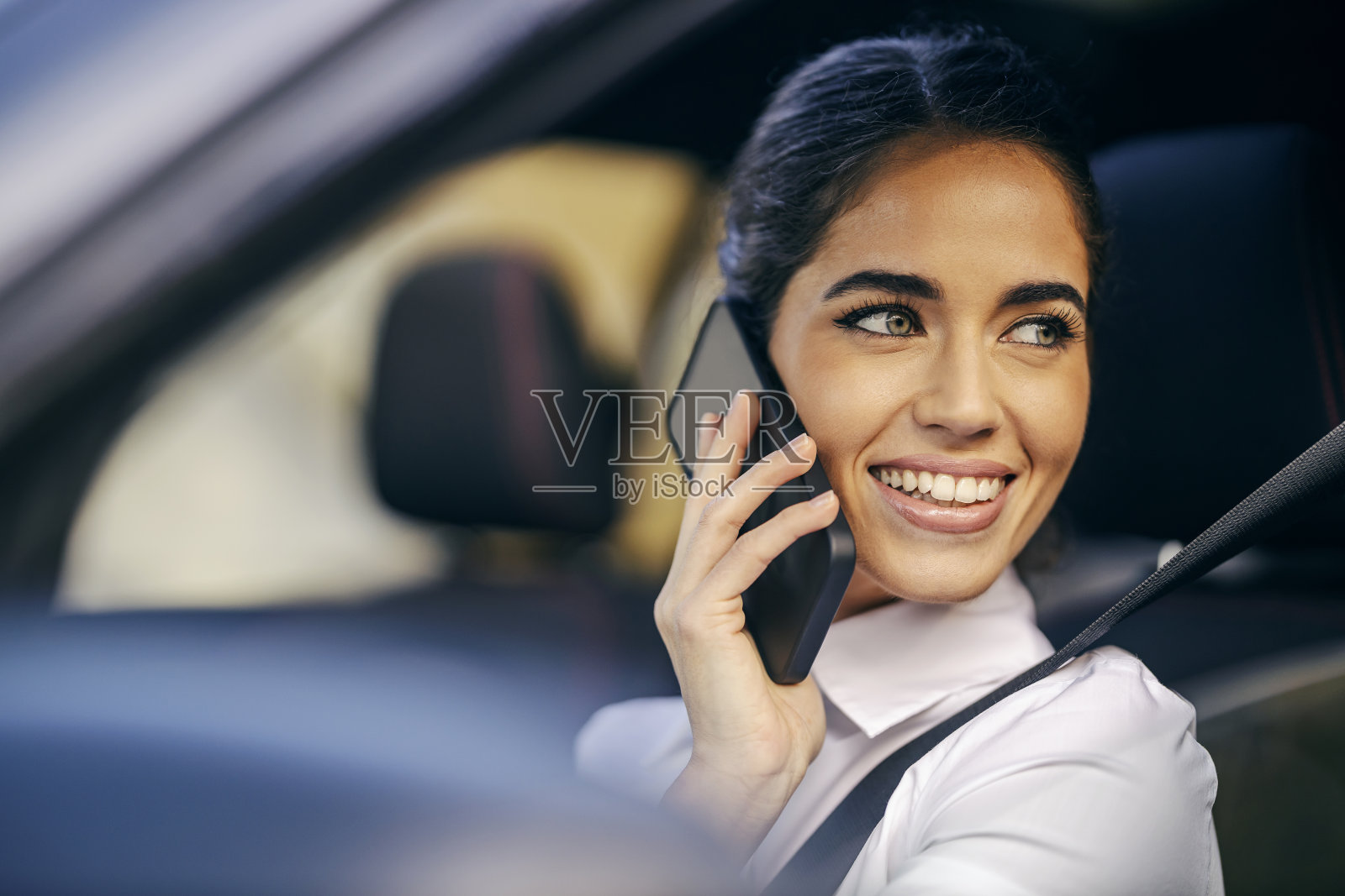 一个忙碌的女人正在车里讲电话。照片摄影图片