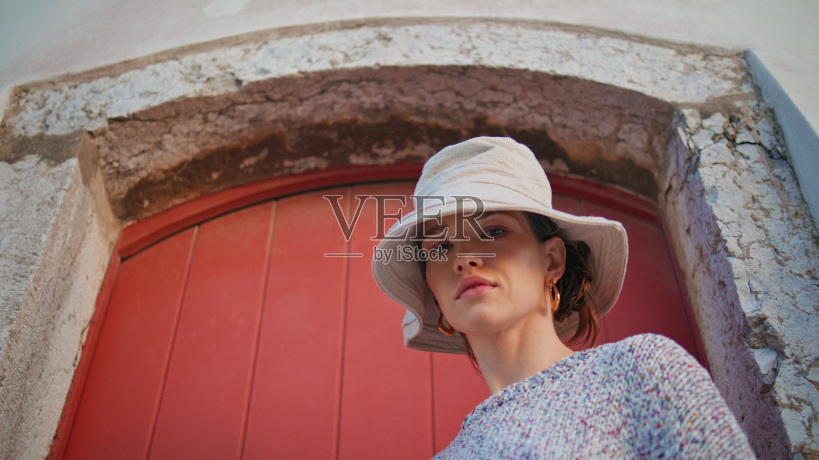 女孩在暑假探索旧城。特写休闲模特在门口摆姿势照片摄影图片