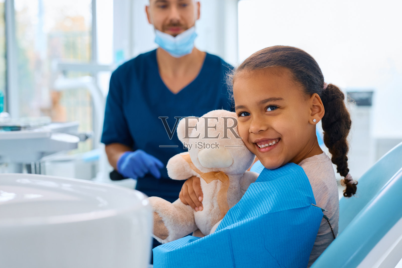 快乐的黑人女孩在牙医办公室看着镜头。照片摄影图片