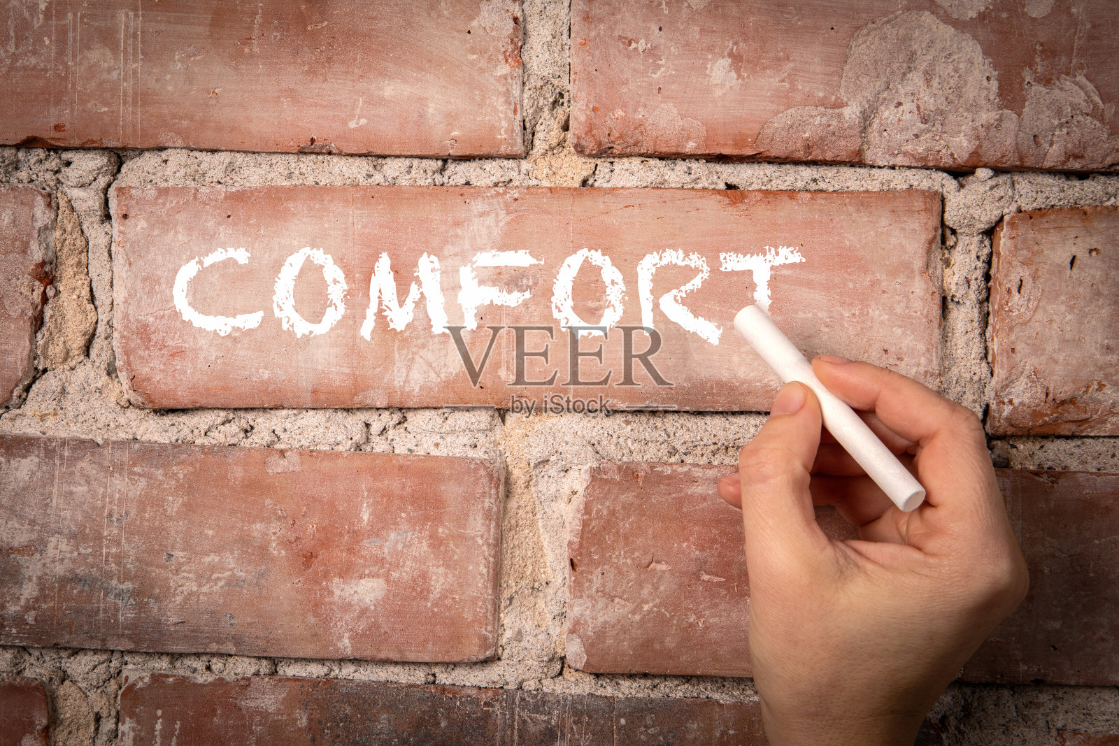 安慰。用白粉笔在红砖背景上写的文字照片摄影图片