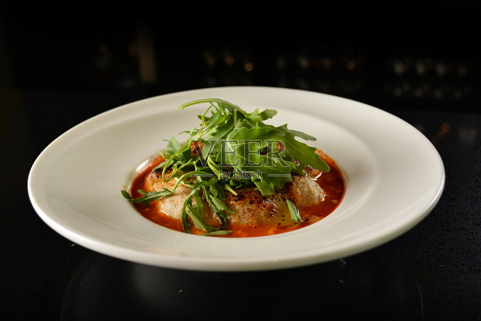 奶酪烤奶酪肉球配红番茄肉酱和绿色蔬菜,餐盘在深色吧台餐厅西式小吃亚洲咖啡馆清真开胃菜菜单照片摄影图片