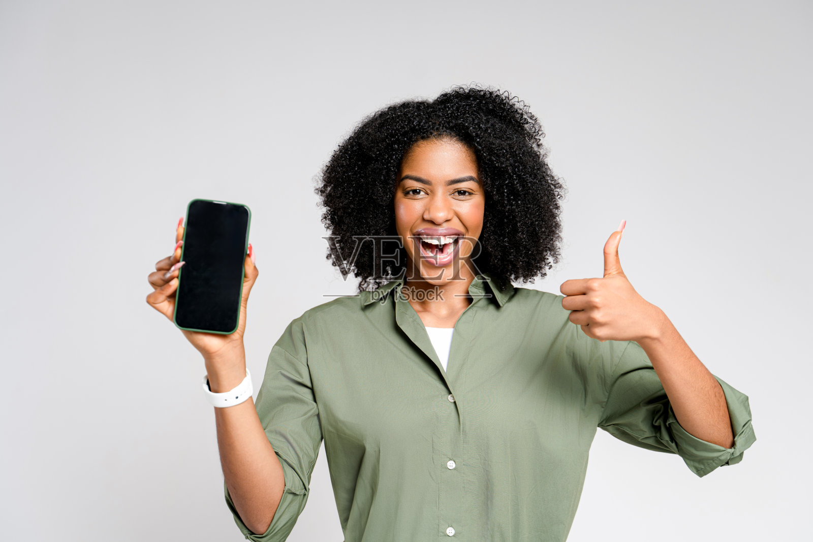 这位非裔美国妇女举起她的智能手机,自信地微笑着照片摄影图片