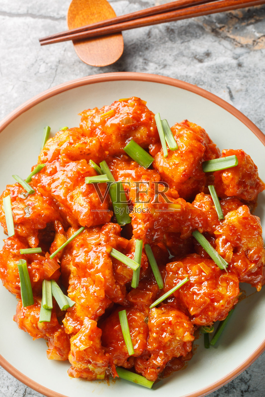 戈壁满洲油炸花椰菜,用浓郁的酱汁煸炒,特写在盘子里。垂直俯视图照片摄影图片