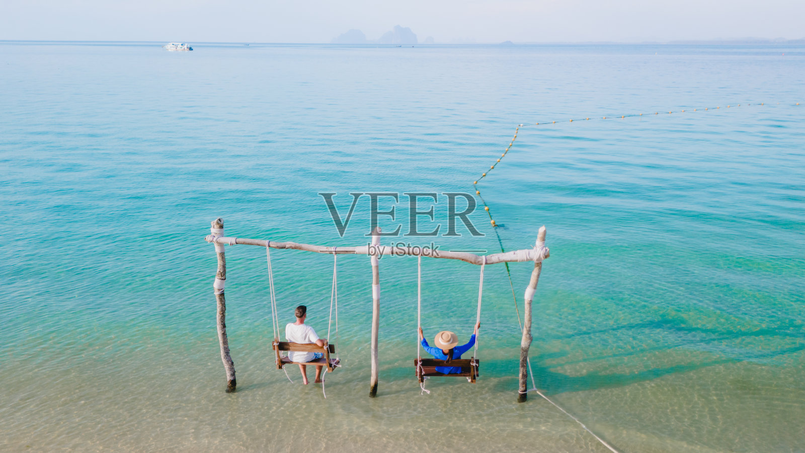 一对男女在泰国木岛的海滩上荡秋千照片摄影图片
