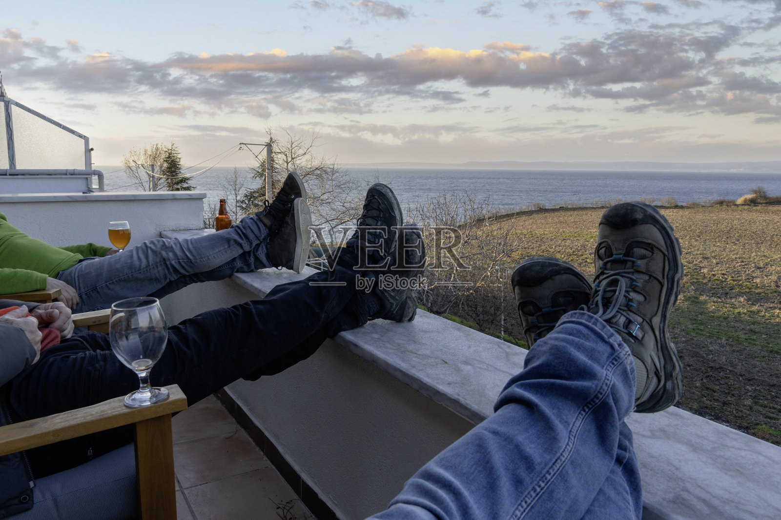 三个人在阳台上伸伸脚。照片摄影图片