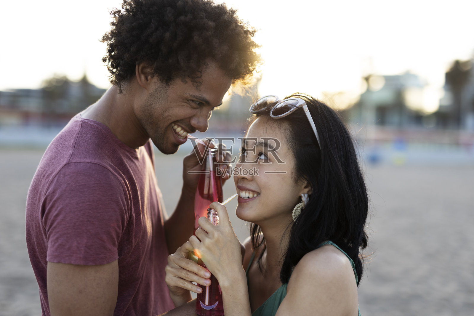 漂亮的年轻夫妇在海滩上享受时光。照片摄影图片