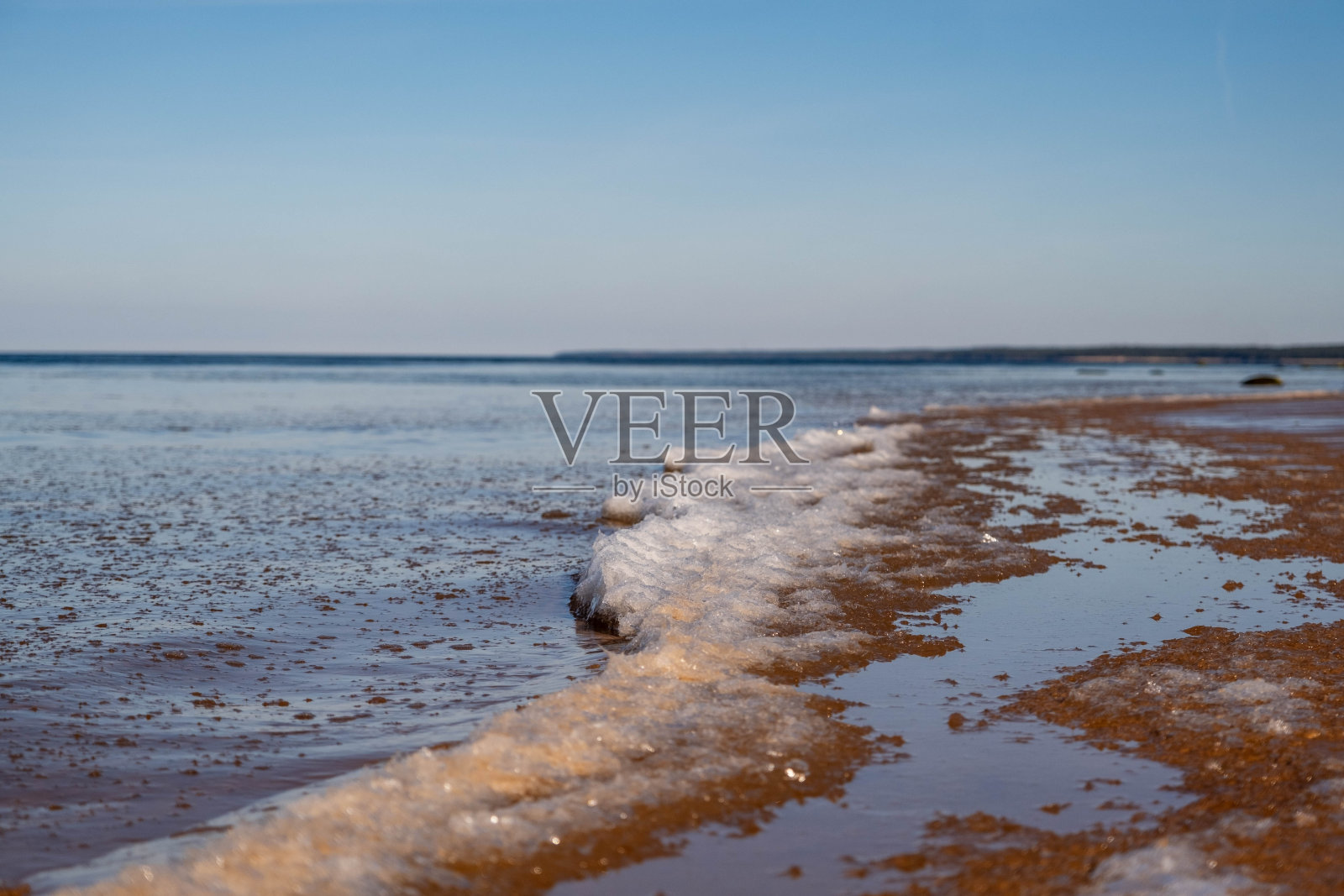 温柔的海浪抚摸着宁静的沙滩海岸线。照片摄影图片