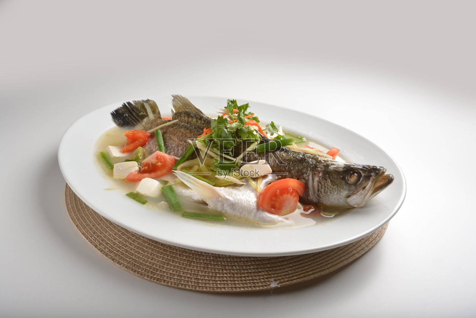 白桌餐厅亚洲咖啡厅清真中式宴席菜单,主厨蒸整条新鲜石斑鱼配豆腐、豆腐、番茄、酸菜和姜,以teo chew sauce风格照片摄影图片