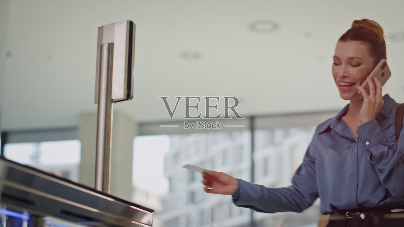 女商人通过安检,近距离讲着智能手机。女人打电话照片摄影图片