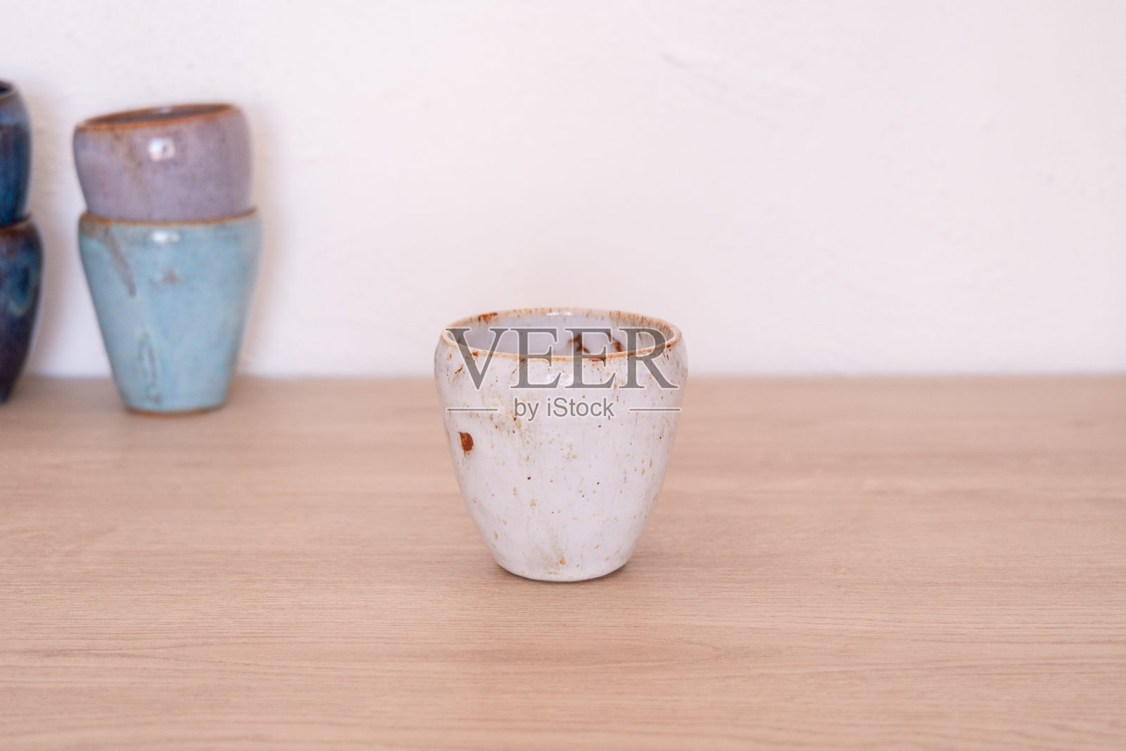 木制桌子上的手工陶瓷杯照片摄影图片