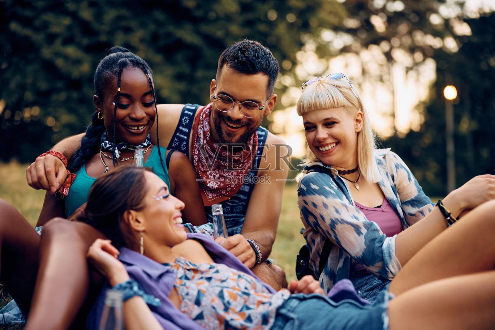 快乐的朋友在大自然中放松,同时在夏天参加露天音乐会。照片摄影图片