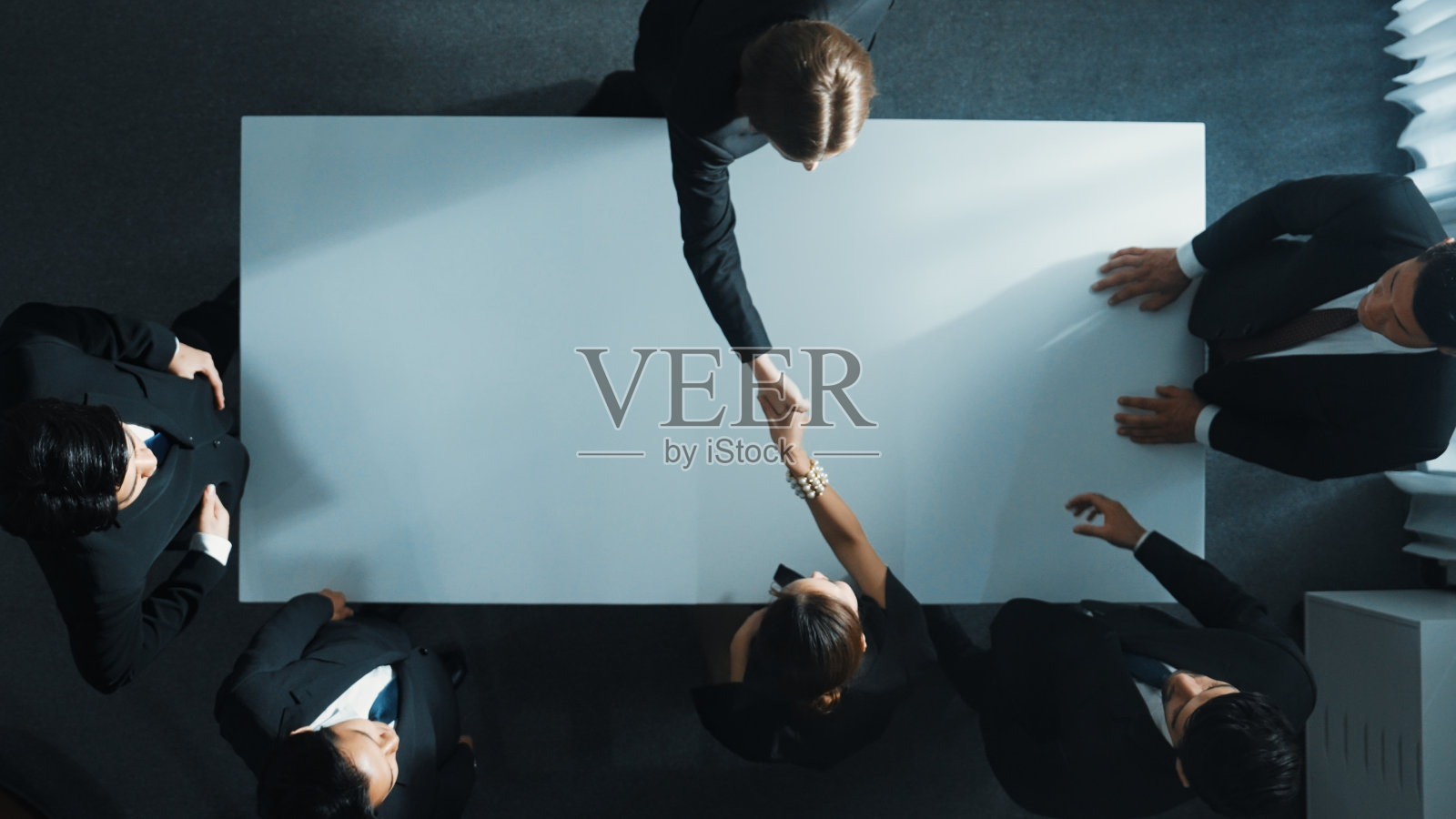 业务团队与项目经理握手的自顶向下视图。理事会。照片摄影图片