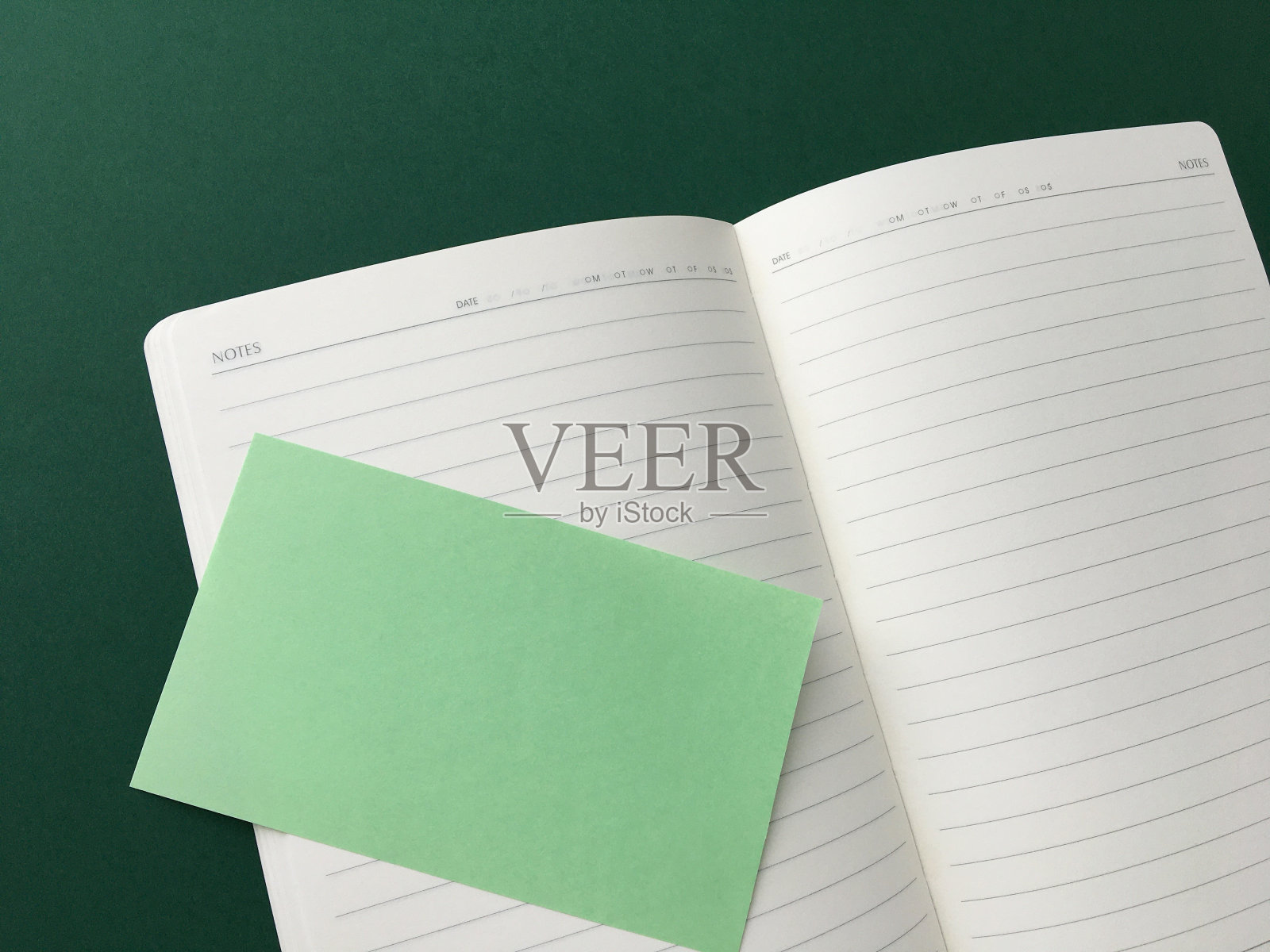 打开记事本和绿色背景的提醒表照片摄影图片