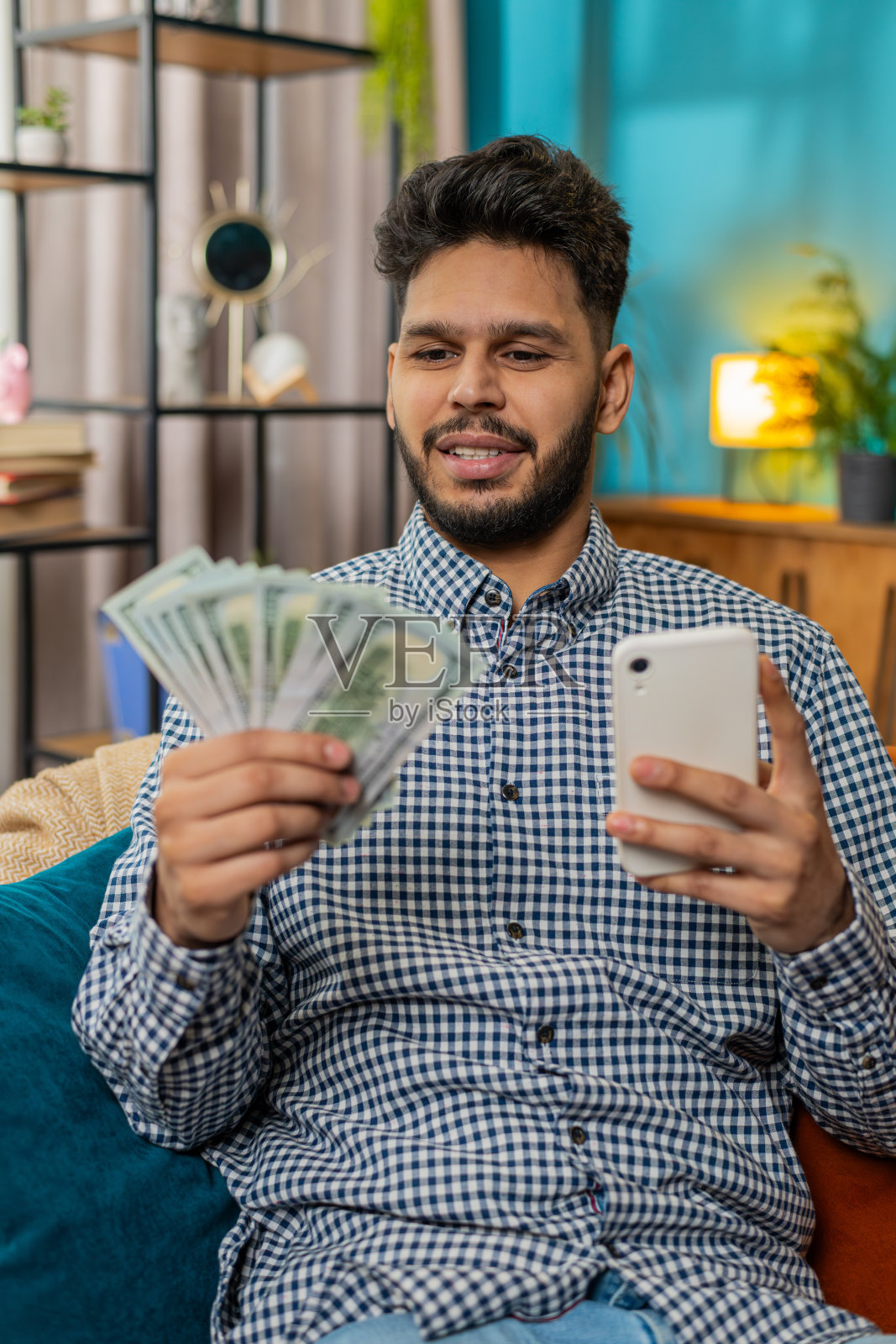 富有快乐的印度人在智能手机计算器应用程序上数钱,计算收入照片摄影图片