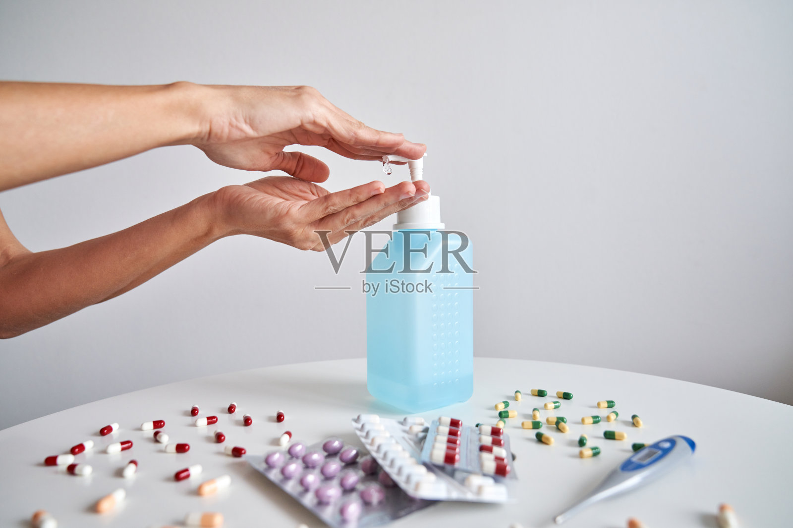 在冠状病毒感染期间,不知名的人将消毒凝胶抽到手上照片摄影图片